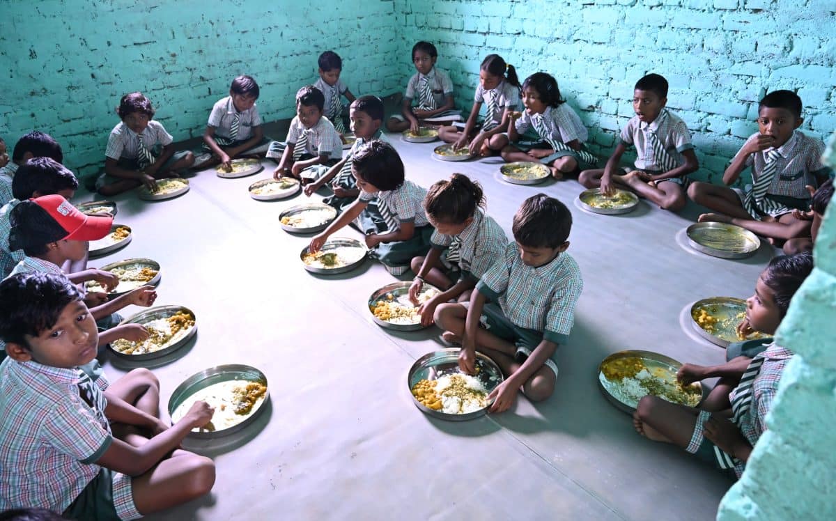 School children in Bantoli, India, sitting down to a generous-sized lunch of rice and daal