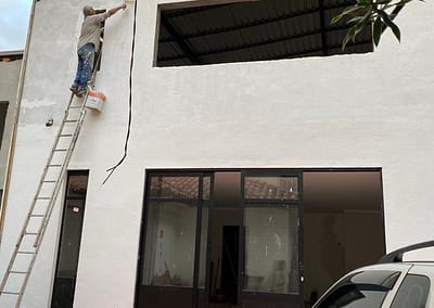 A photo of a man painting the outside of a new kitchen to feed the homeless in Brazil that was funded by The Prem Rawat Foundation