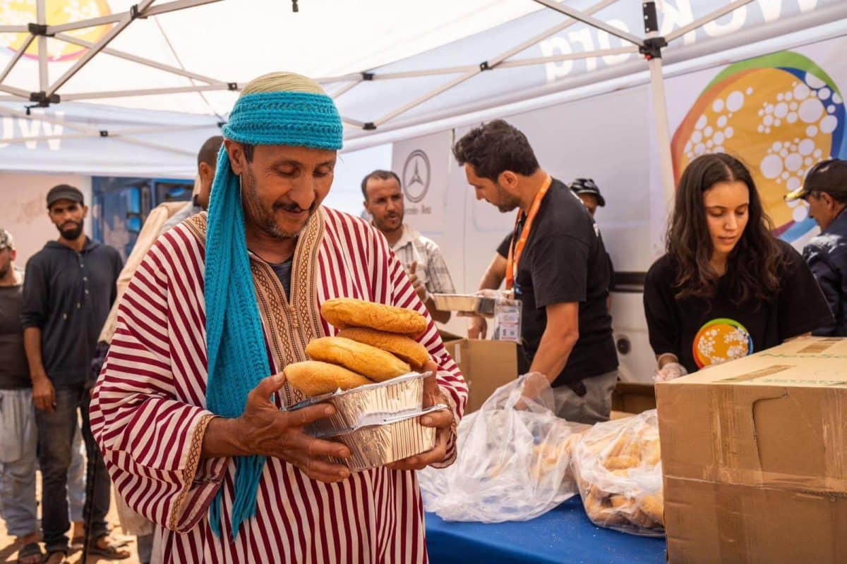 Una vittima del terremoto in Marocco riceve pane fresco e generi alimentari. La Fondazione Prem Rawat manda questi aiuti.