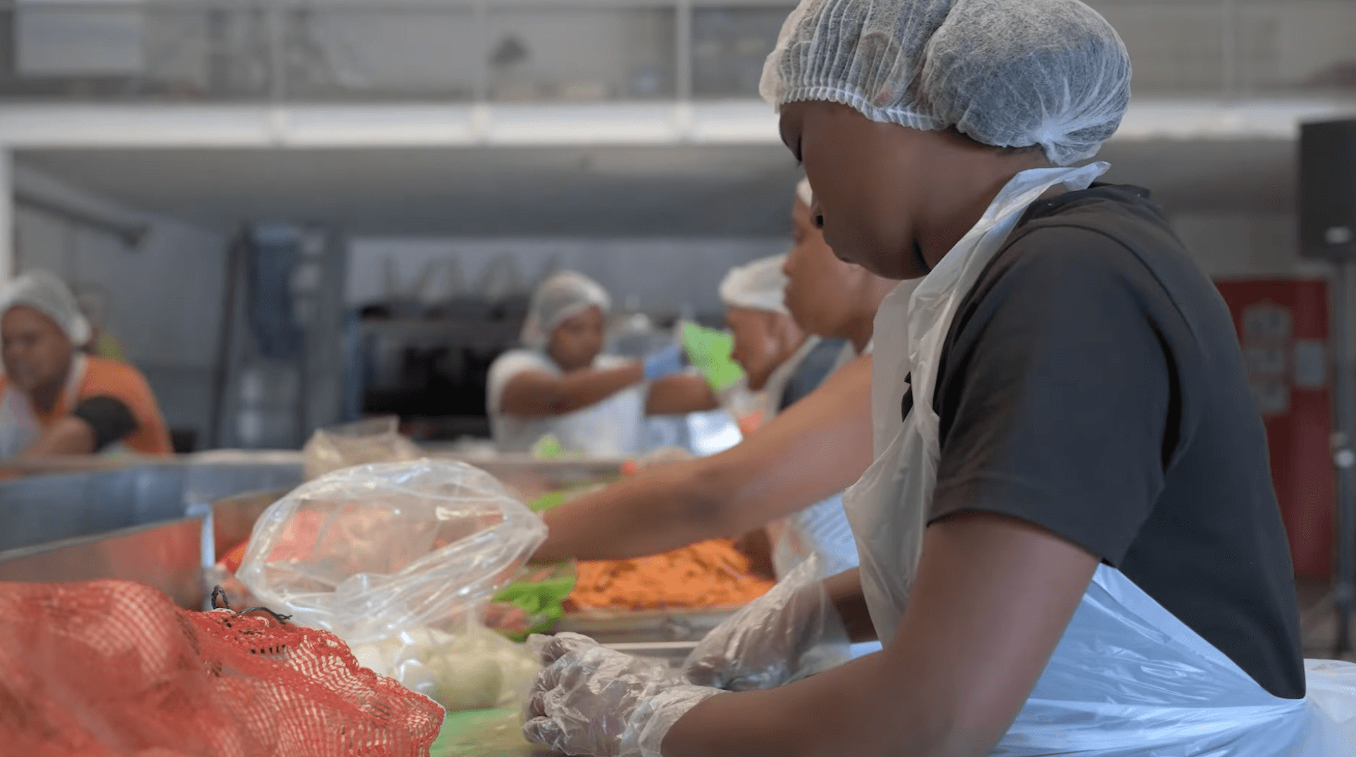 Kitchen staff prepare fresh vegetables at the hyper-clean work stations inside the Food For People facility in Cape Flats